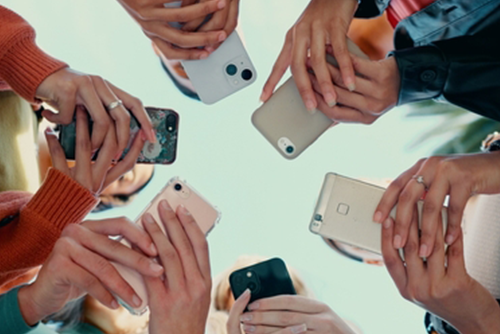 A group of students using their phones to access an online platform.